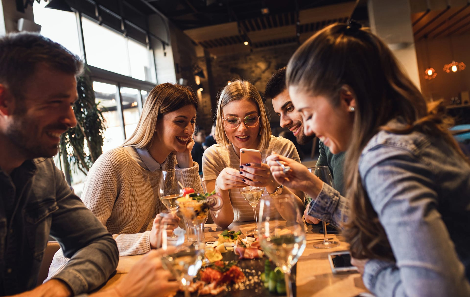Cinci tineri la masă într-un restaurant