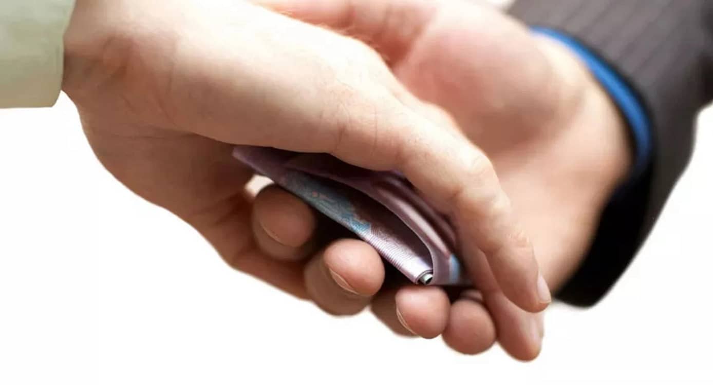 Cineva maschează cu mâna mita pe care o dă cuiva în palmă