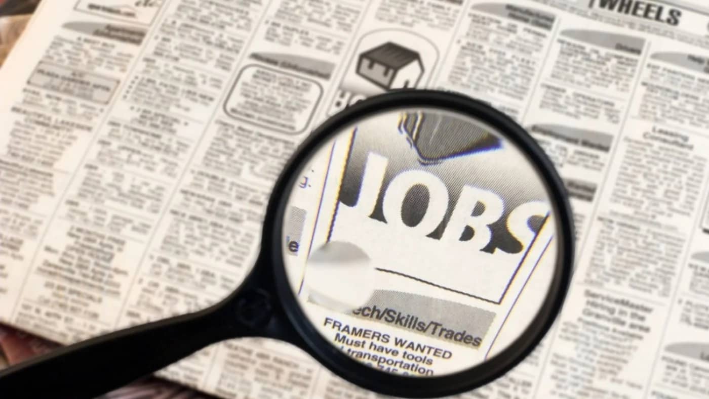 Lupa pusă pe cuvântul Jobs dintr-un ziar